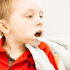 [Alt-text]: a child with his mouth open as therapist inserts oral probe into mouth during feeding therapy  